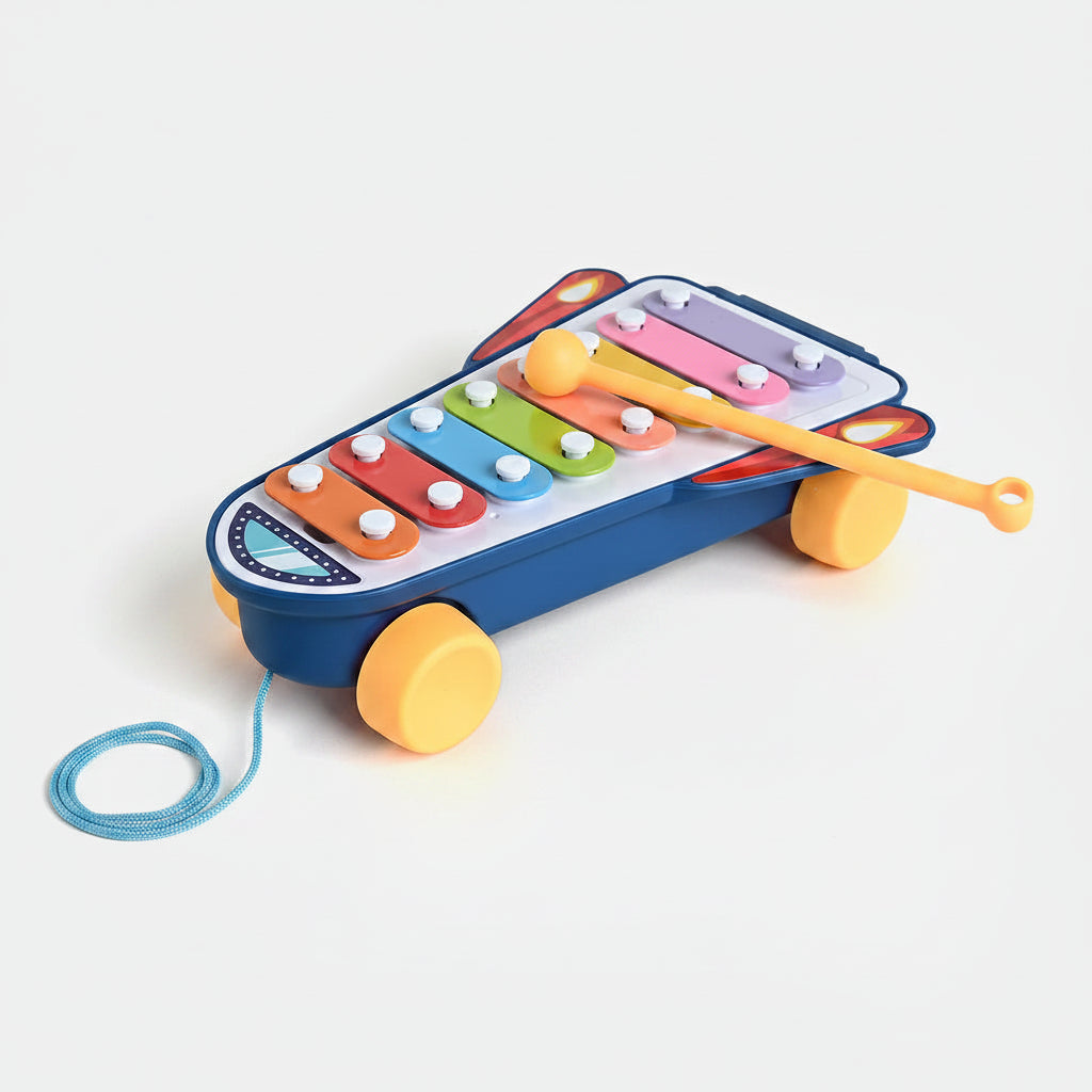 Colorful toy xylophone with a stick on a light gray background