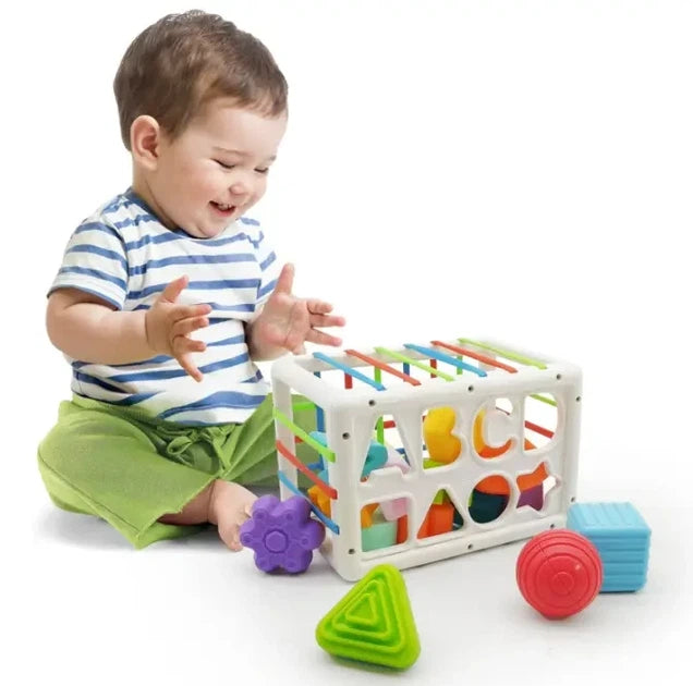 Child playing with a colorful toy box and blocks on a white background