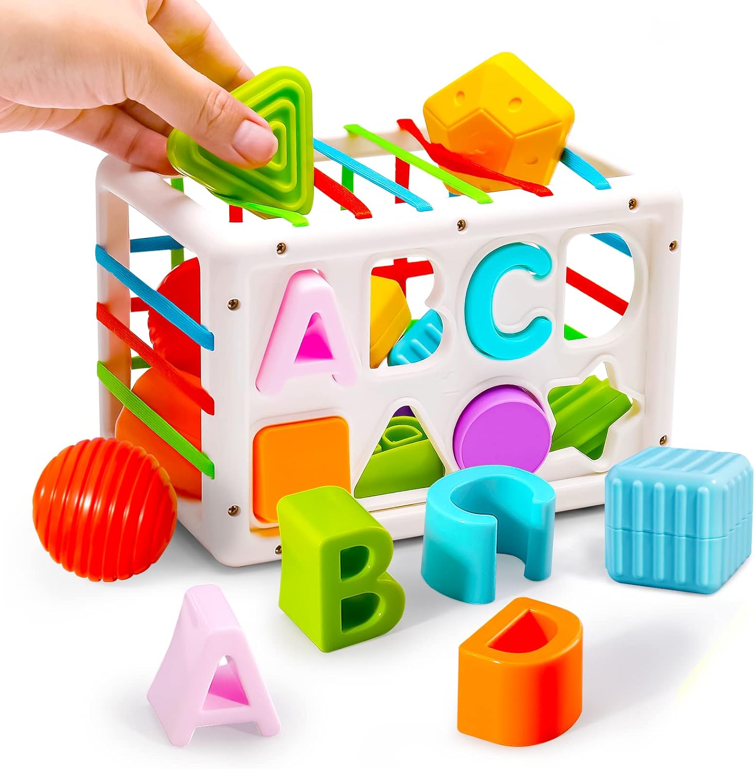 Colorful toy cube with letters and shapes, hand interacting with a green shape block.