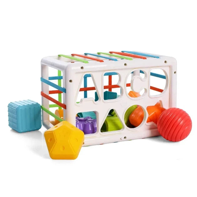 Colorful toy cube with various shapes and a ball on a white background