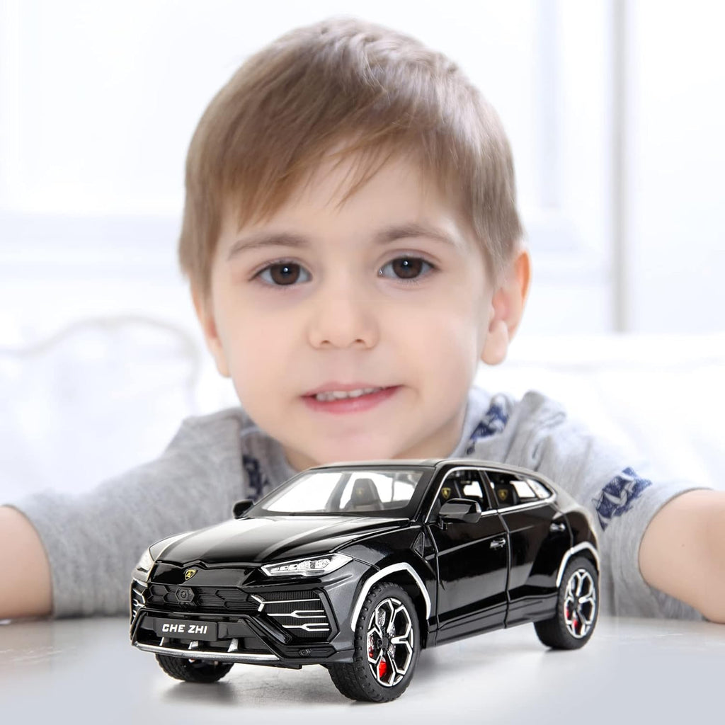 Child holding a black toy SUV with a blurred background