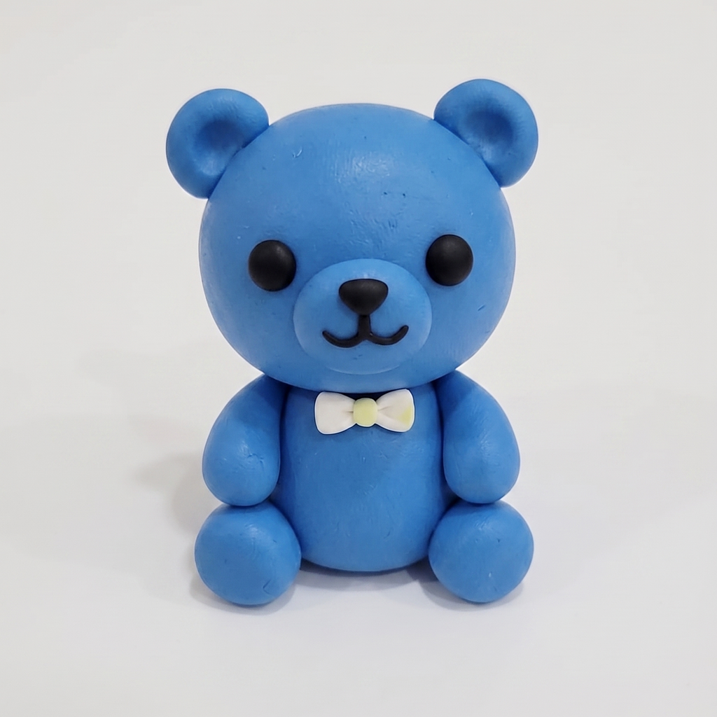 Blue teddy bear figurine with a white bow tie on a white background