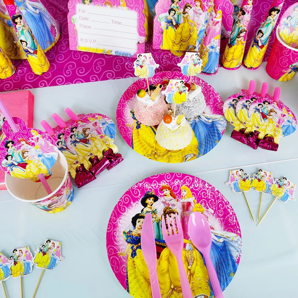 A Disney Princess party table setting with matching paper plates, pink plastic forks and spoons, cup lids, napkins, and dessert picks featuring illustrated princess characters on a white tabletop.